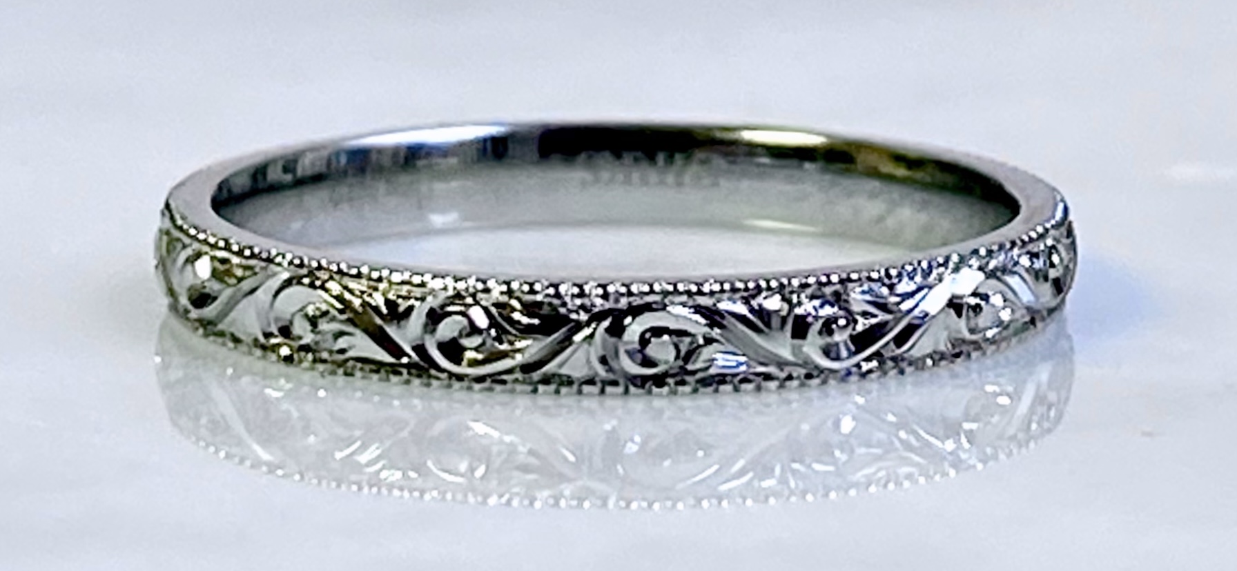 Platinum wedding band with deep scrollwork hand-engraving and milgrain — Toronto goldsmith