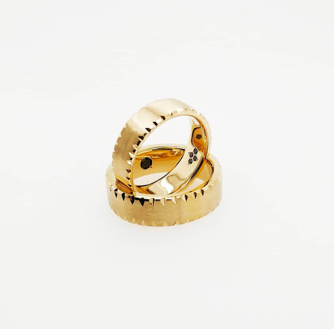 14k yellow gold wedding band pair with hand-engraved notched serrated edges and hidden black diamonds — Bear Goldsmithing Toronto