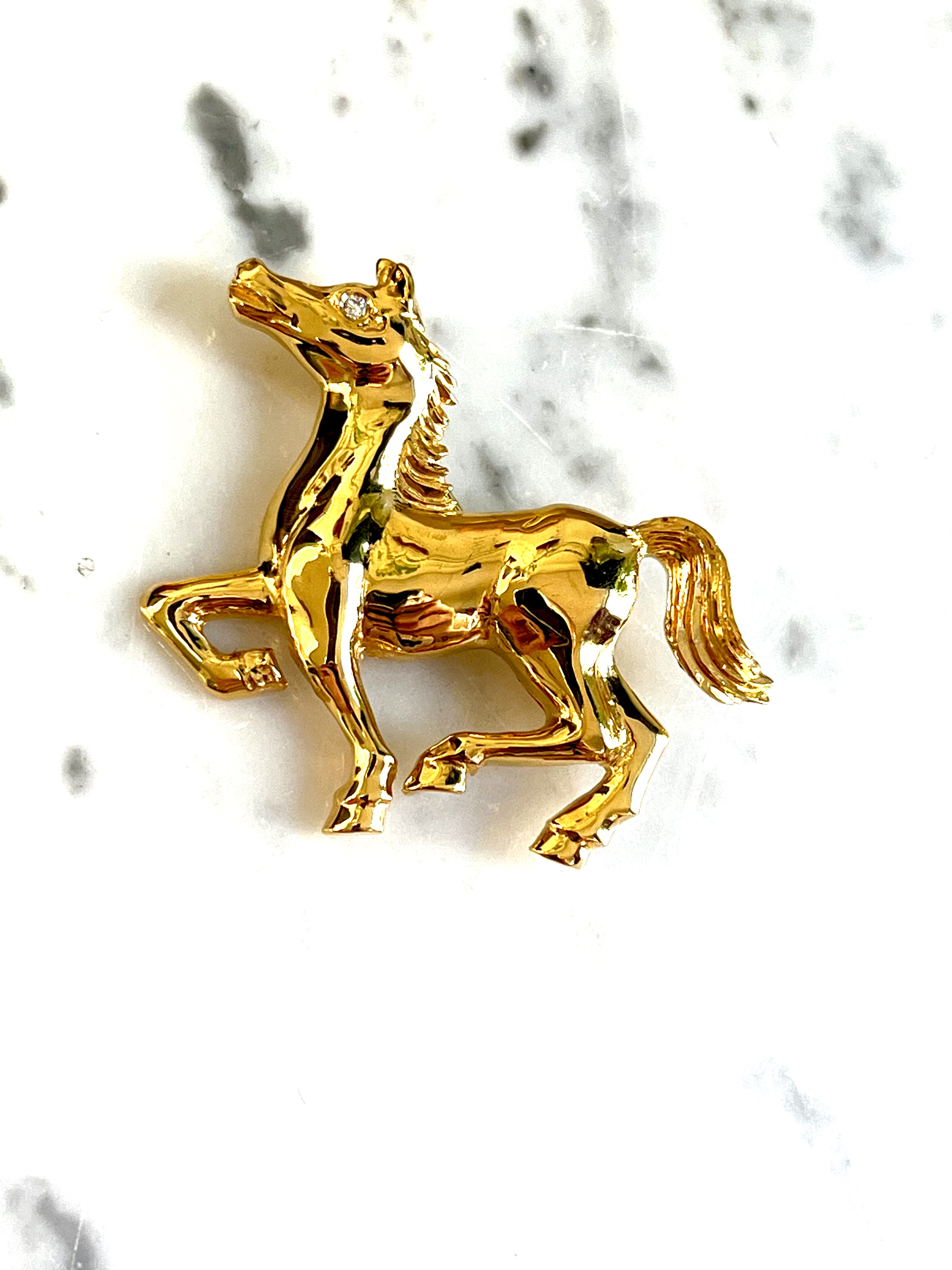 24k gold horse brooch on marble