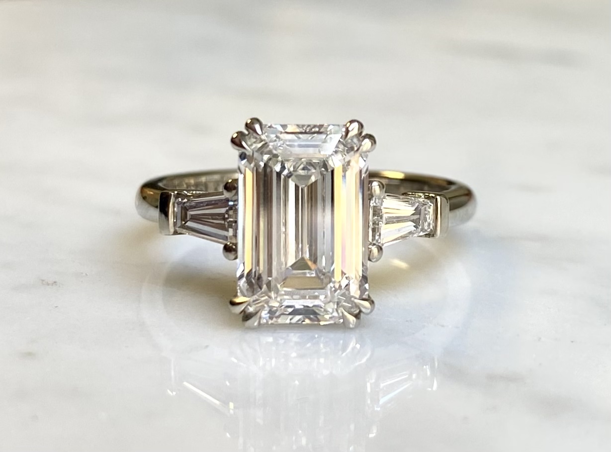 Emerald cut diamond with tapered baguettes in 18k white gold — custom engagement ring Toronto