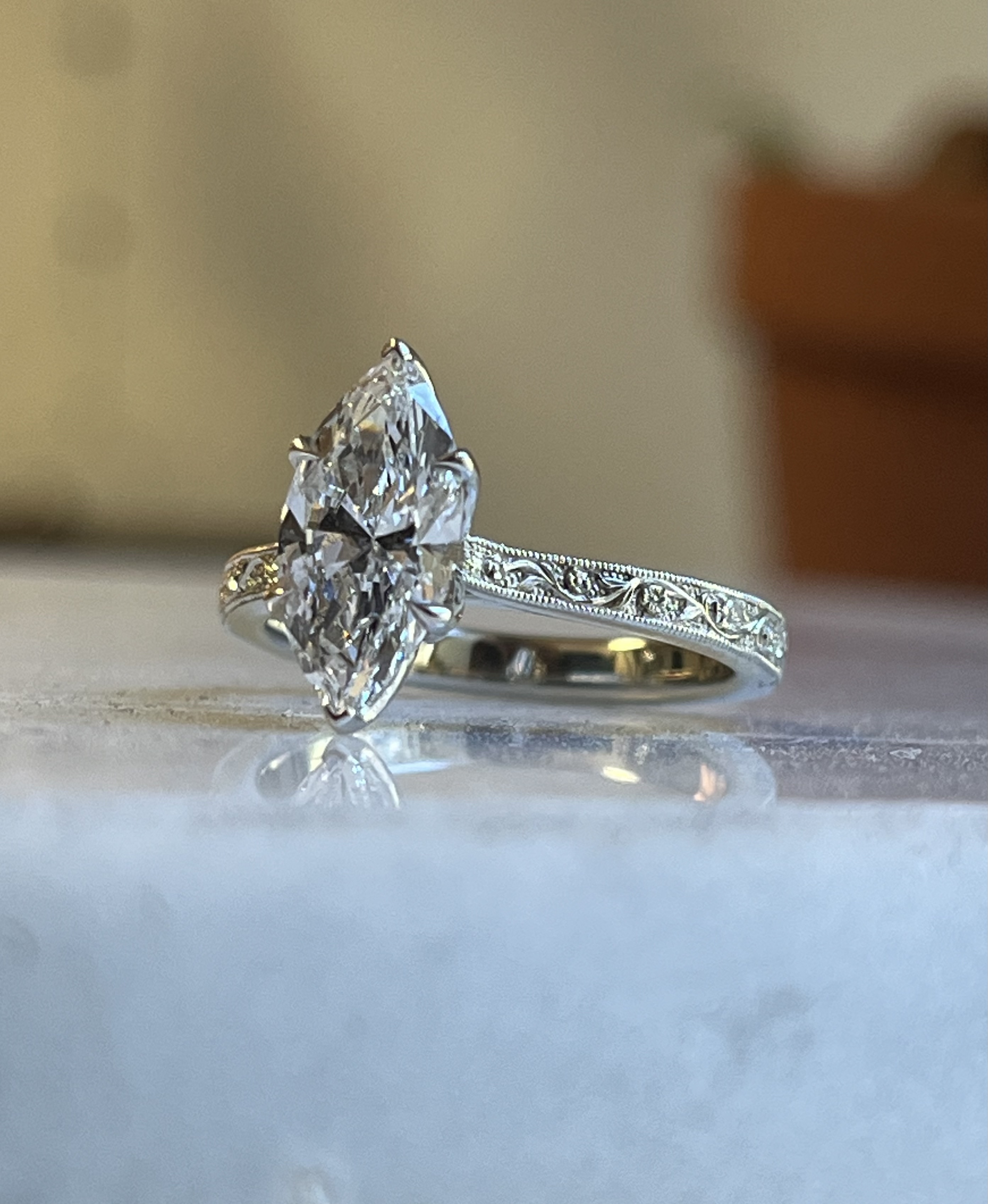 Marquise solitaire relief floral engraved white gold engagement ring with milgrain edge and flush-set accent diamonds — Bear Goldsmithing Toronto