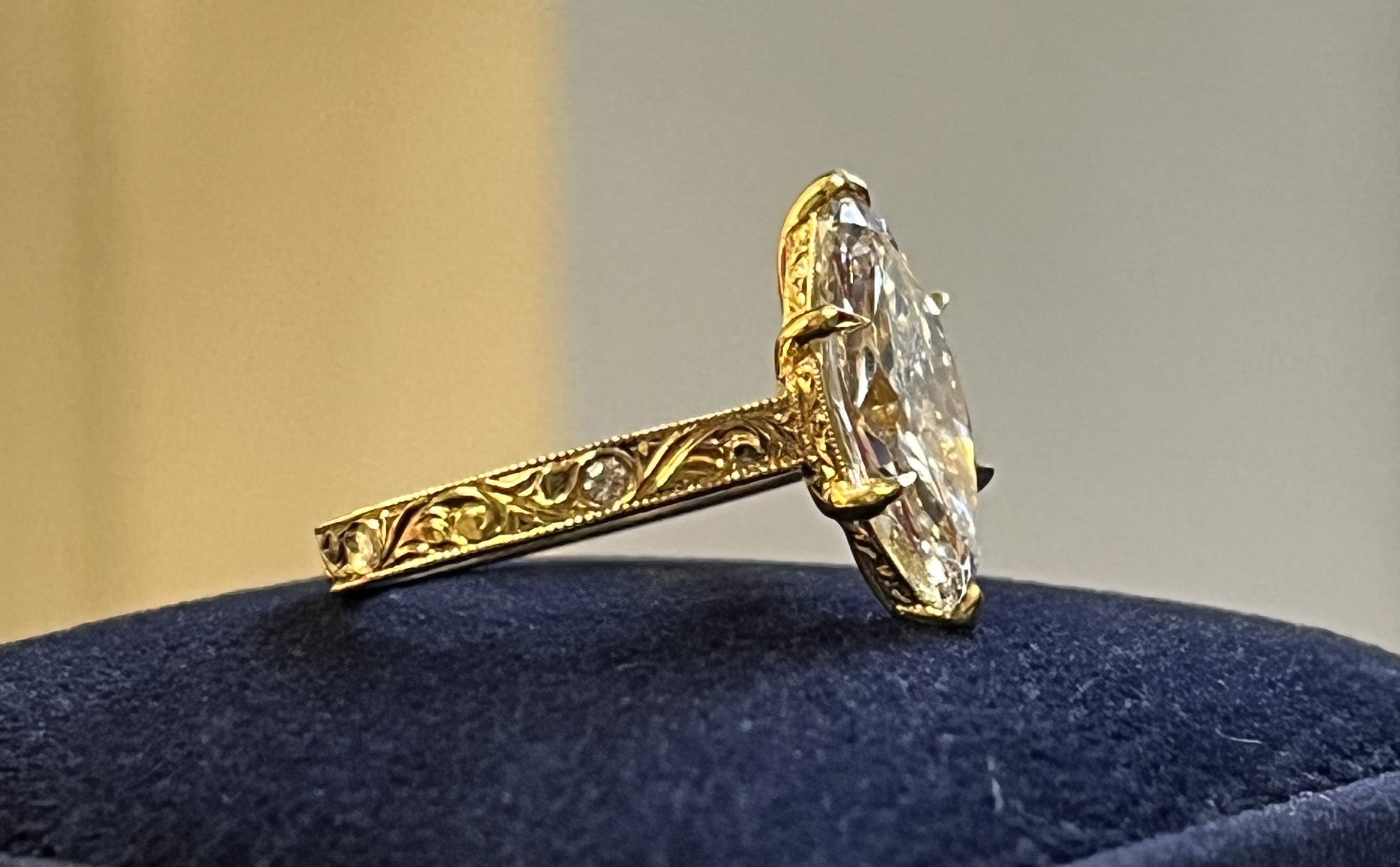 Marquise diamond solitaire yellow gold side profile showing engraved gallery rail scrollwork band and accent diamonds — Bear Goldsmithing Toronto