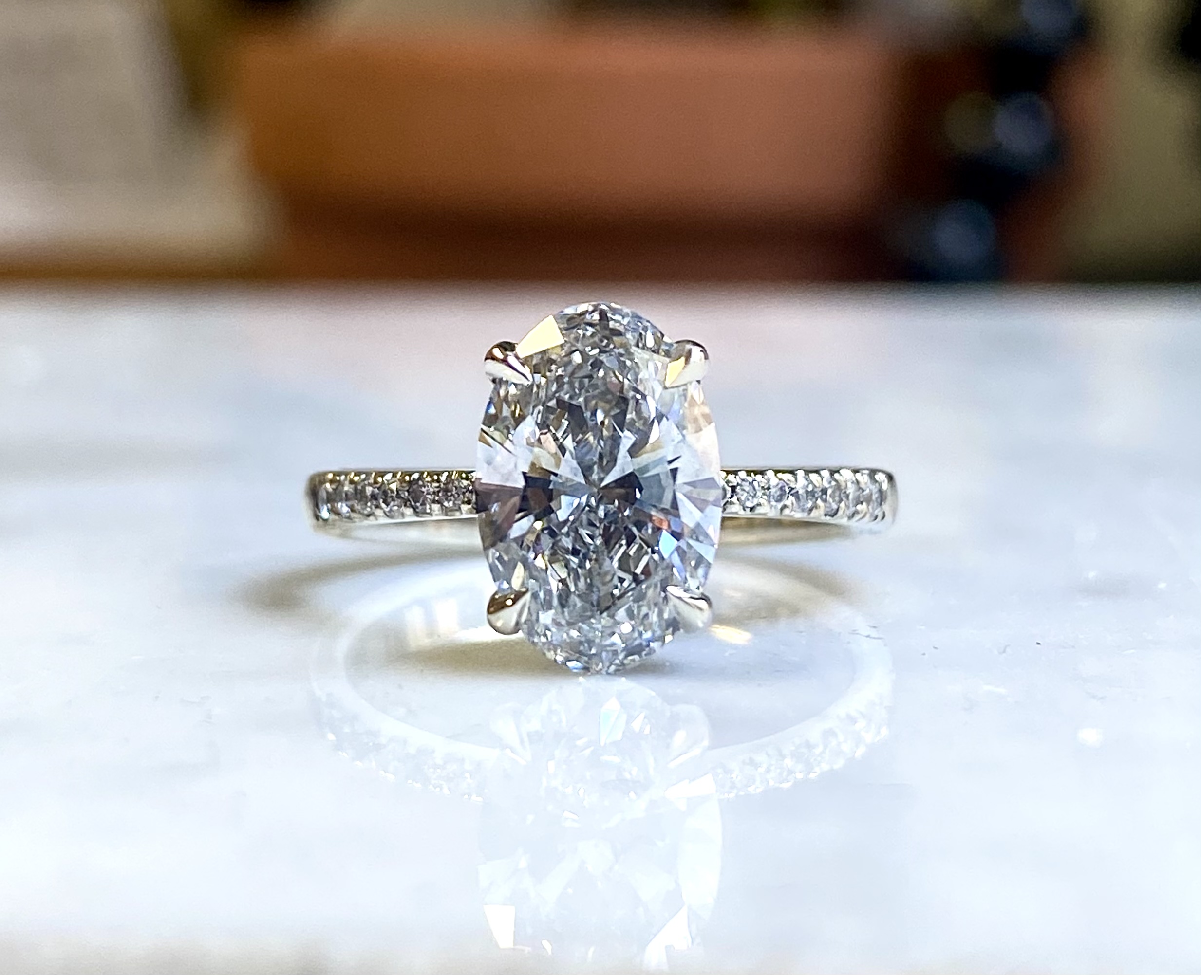 18k white gold oval diamond engagement ring with tasteful side diamonds pave band — Bear Goldsmithing Toronto