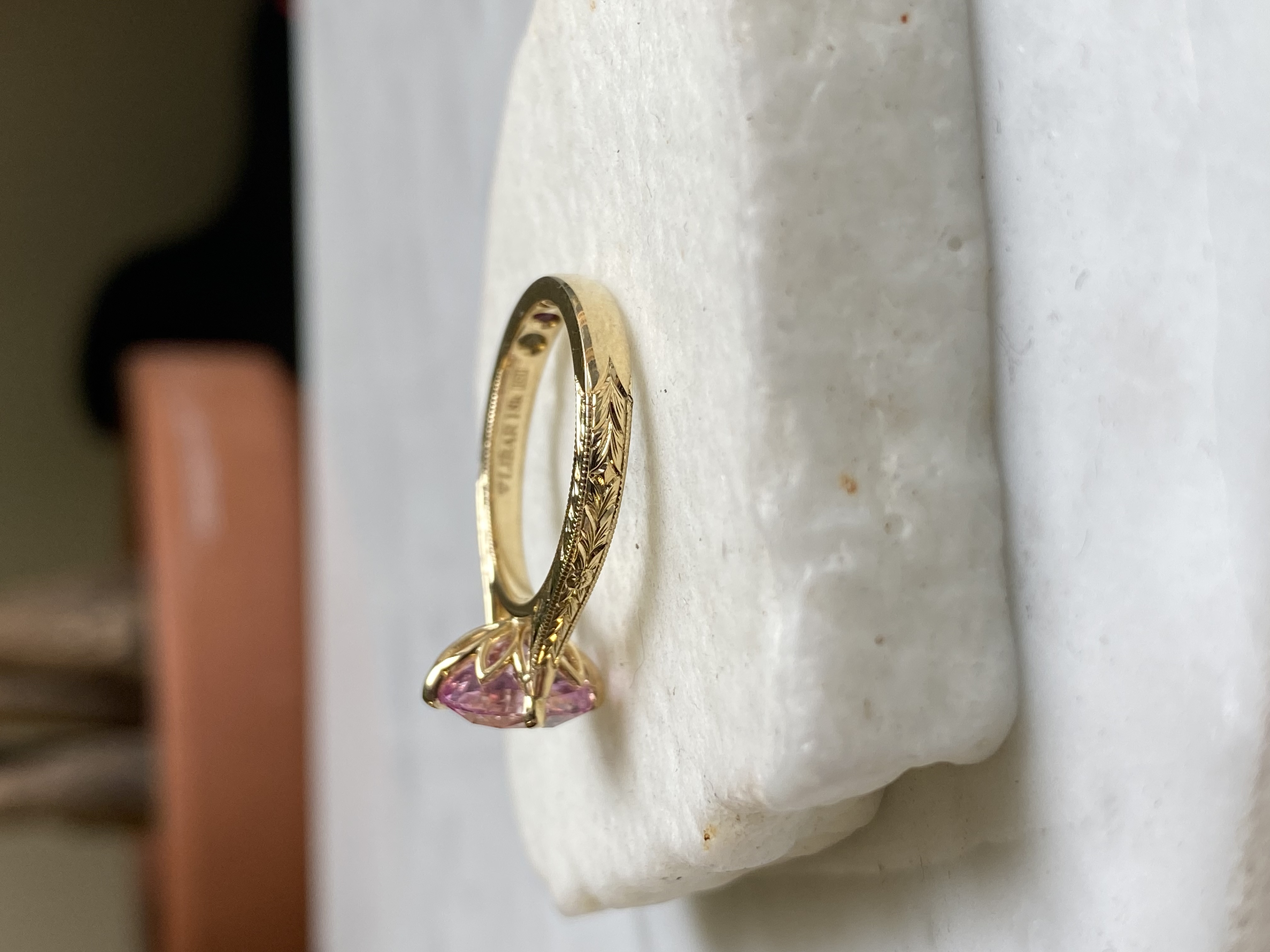 Pink sapphire oval ring side profile showing wheat engraving milgrain leaf claws and inscription inside — Bear Goldsmithing Toronto