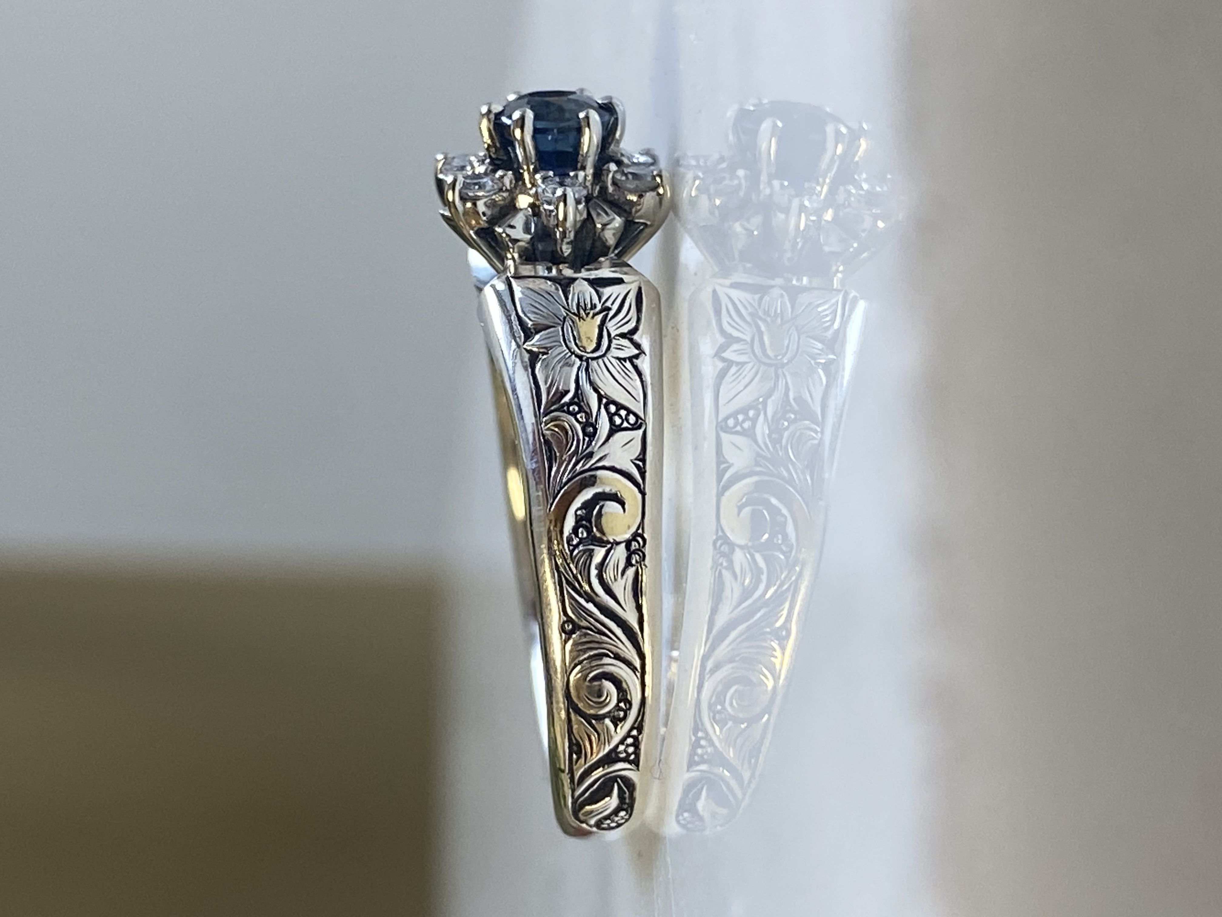 Sapphire engagement ring with deep floral hand-engraving